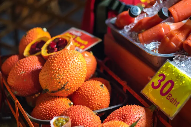 ผลฟักข้าวสุกสีส้มบนแผงตลาดไทย
